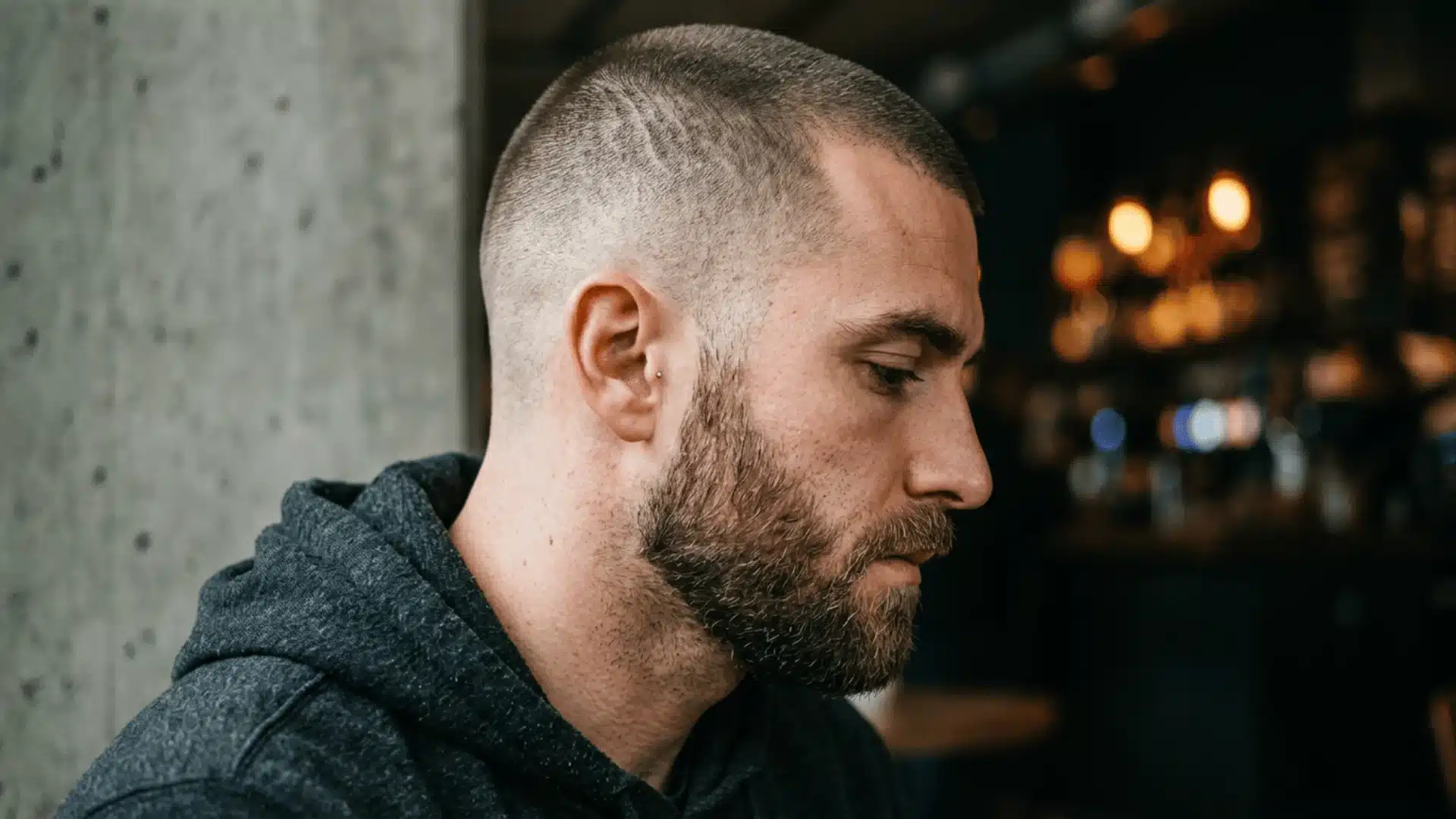 Muscular man with a medium buzz cut paired with a thick full beard and faded sides