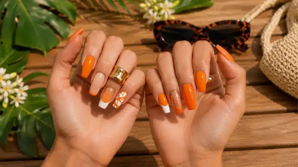 Orange summer nail art with floral accents and French tips