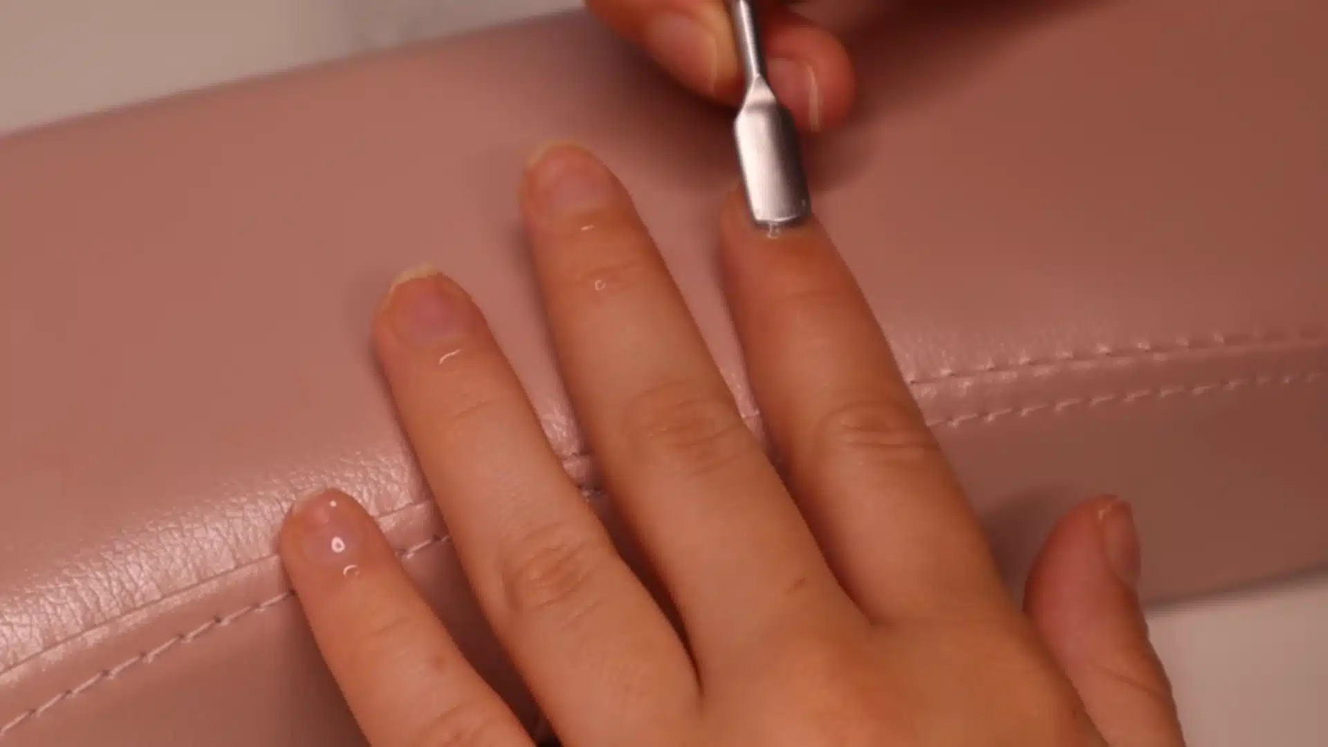 Push back the skin gently with a flat cuticle pusher during beginner nail care