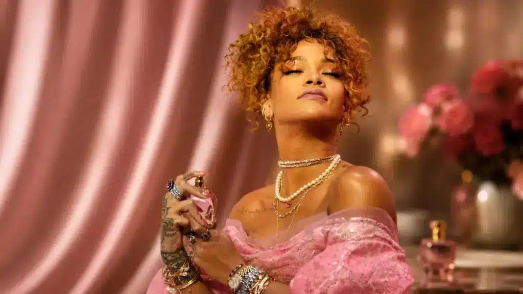 Rihanna spraying perfume in a pink luxury fragrance scene