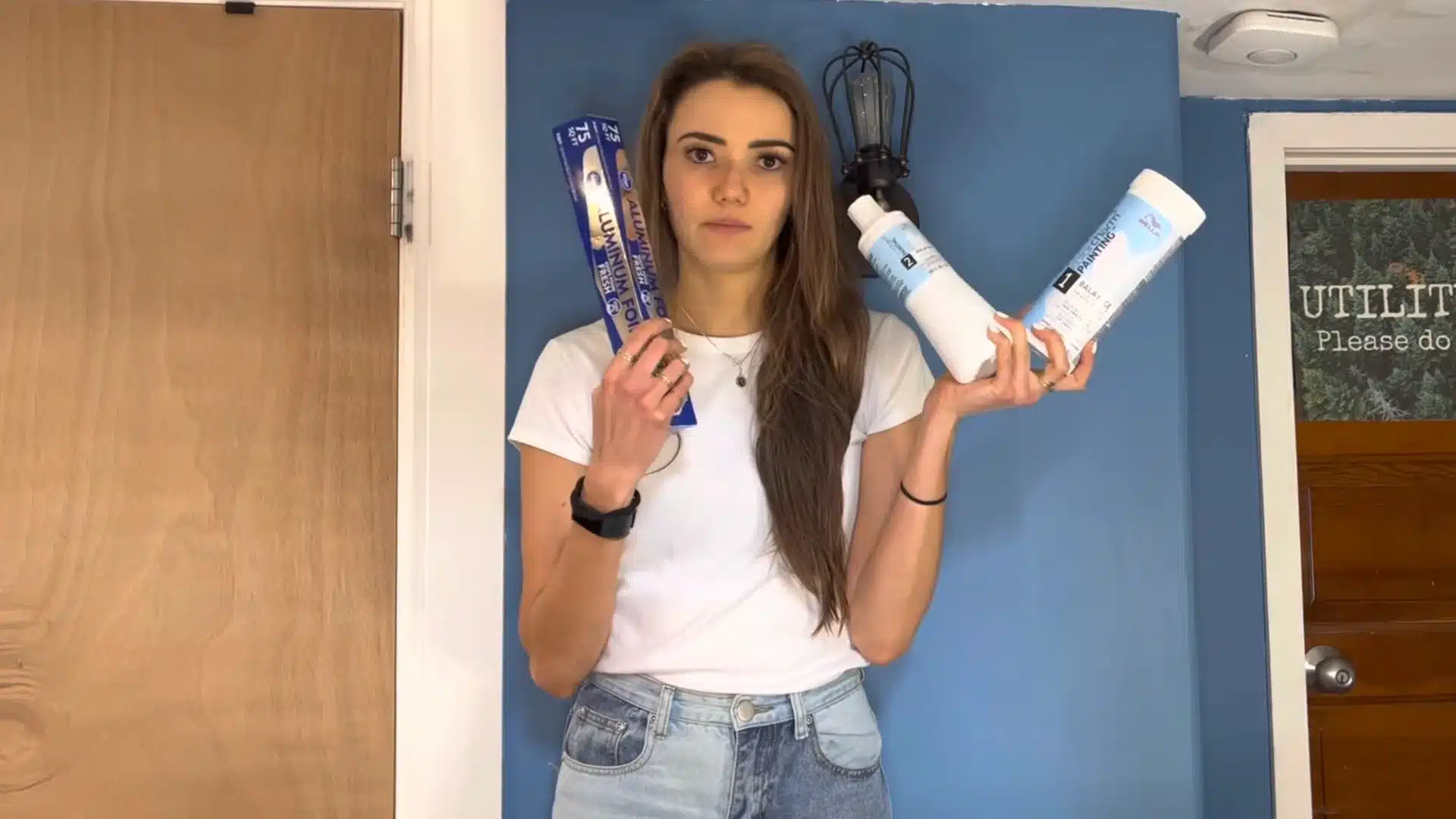 Woman holding bleach, developer, and foil for at home hair highlighting tutorial