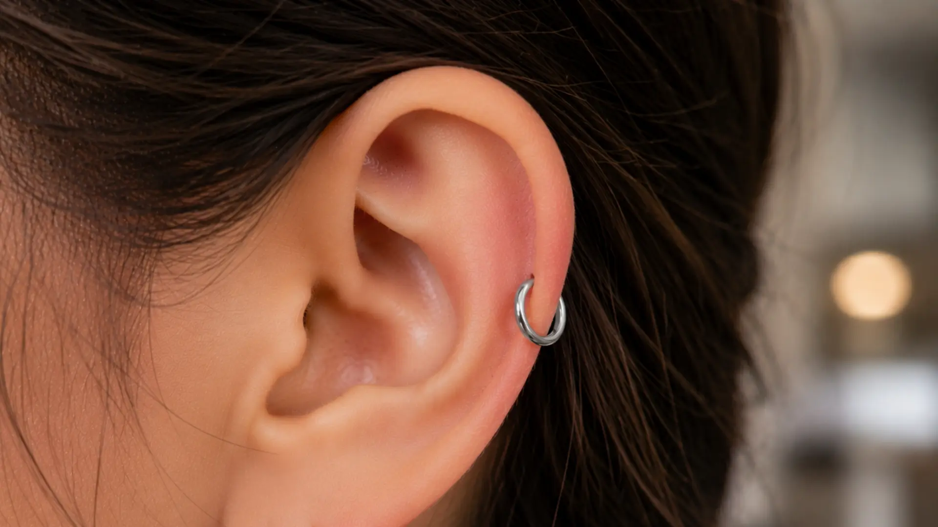Auricle piercing with silver hoop