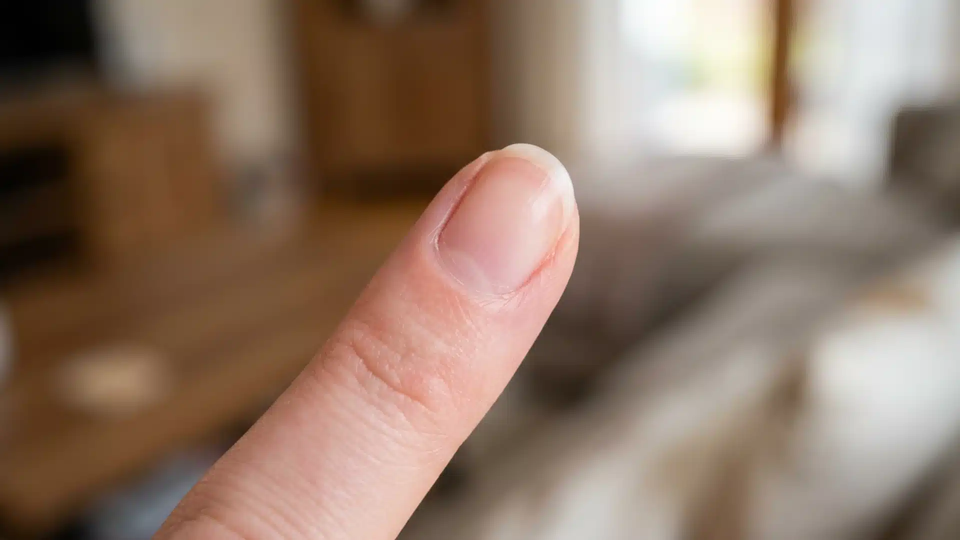 Close-up of a round nail shape with softly curved tip on a natural bare finger