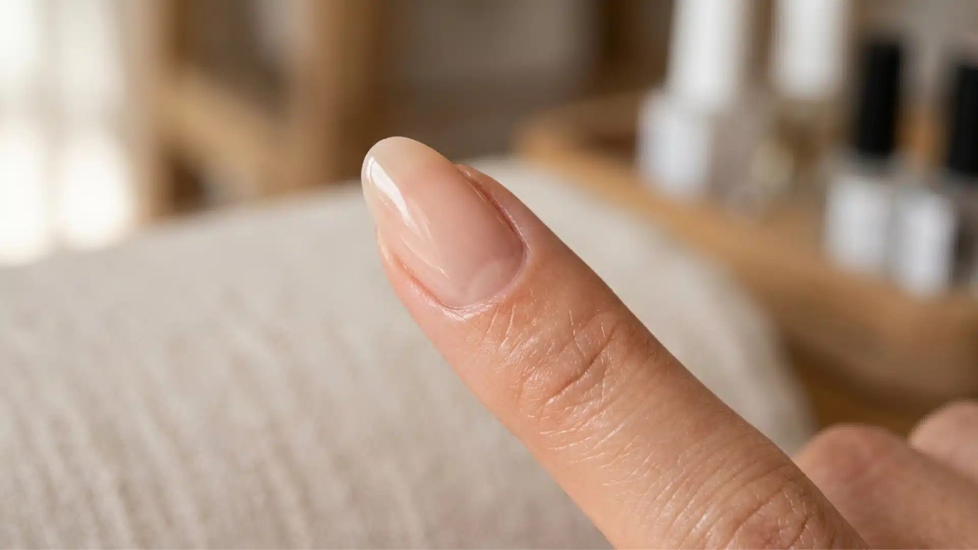 Close-up of an oval nail shape with tapered sides and rounded tip on a bare finger