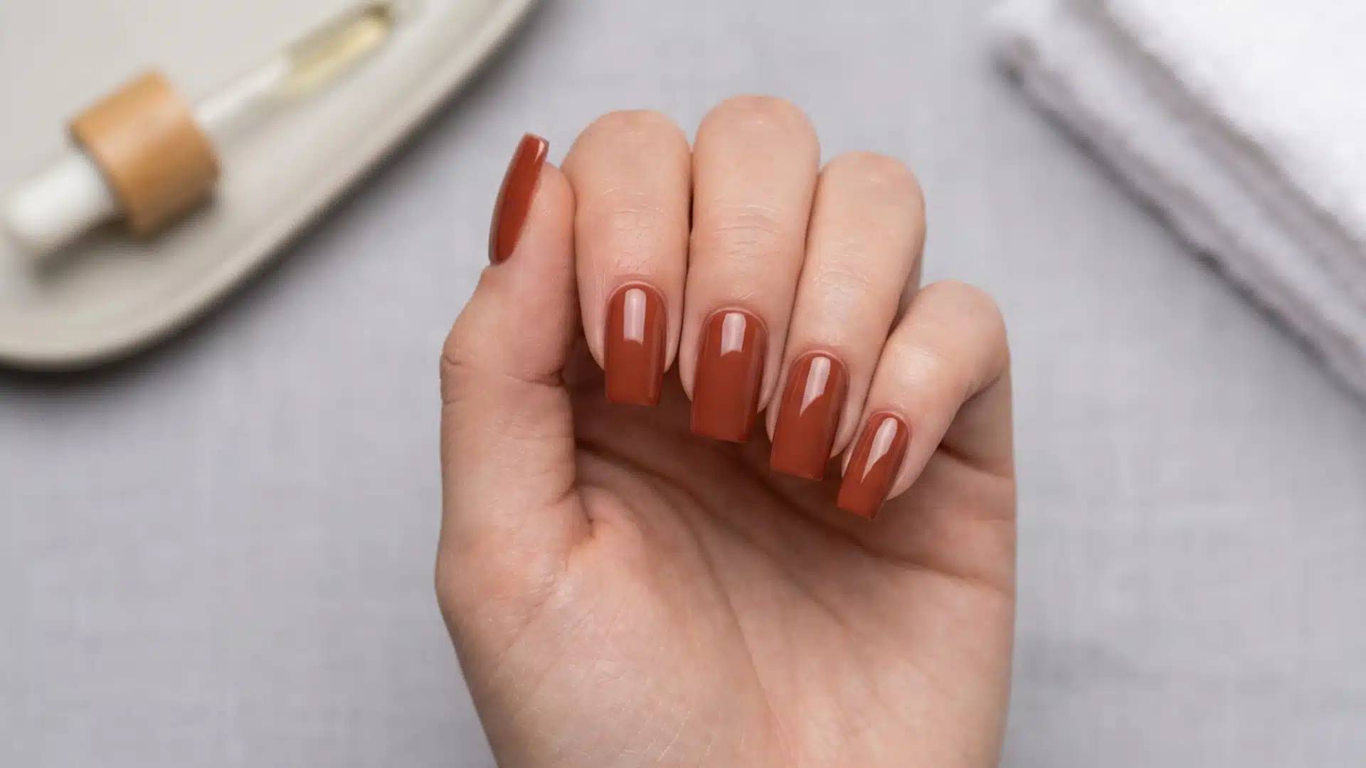 Dip Powder.jpg shows long, glossy square nails in a warm terracotta brown shade, next to a dropper bottle