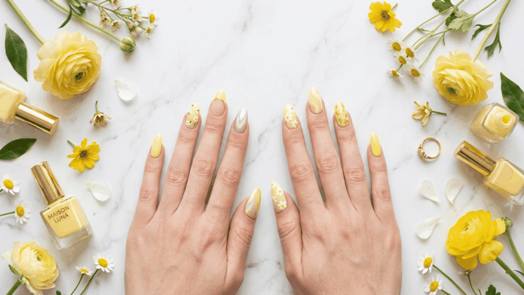 Hands with trendy butter yellow nail designs featuring floral, French tip, and glossy manicure ideas