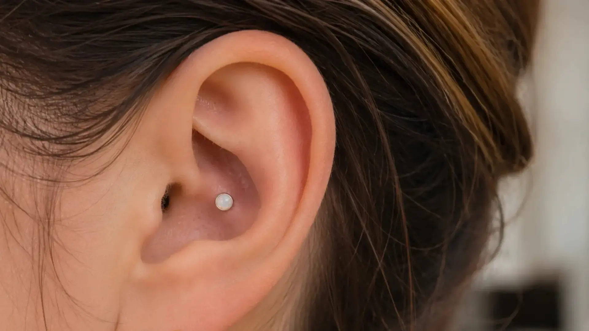 Inner conch piercing with opal stud