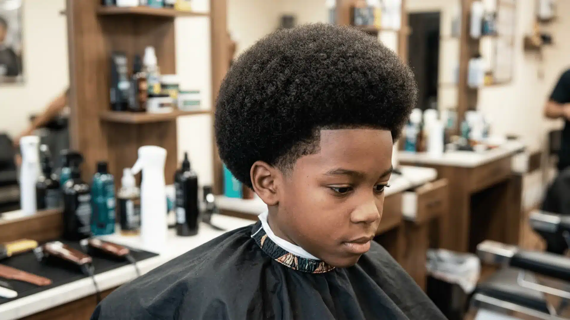 Mixed boy with a full shaped afro and rounded natural volume
