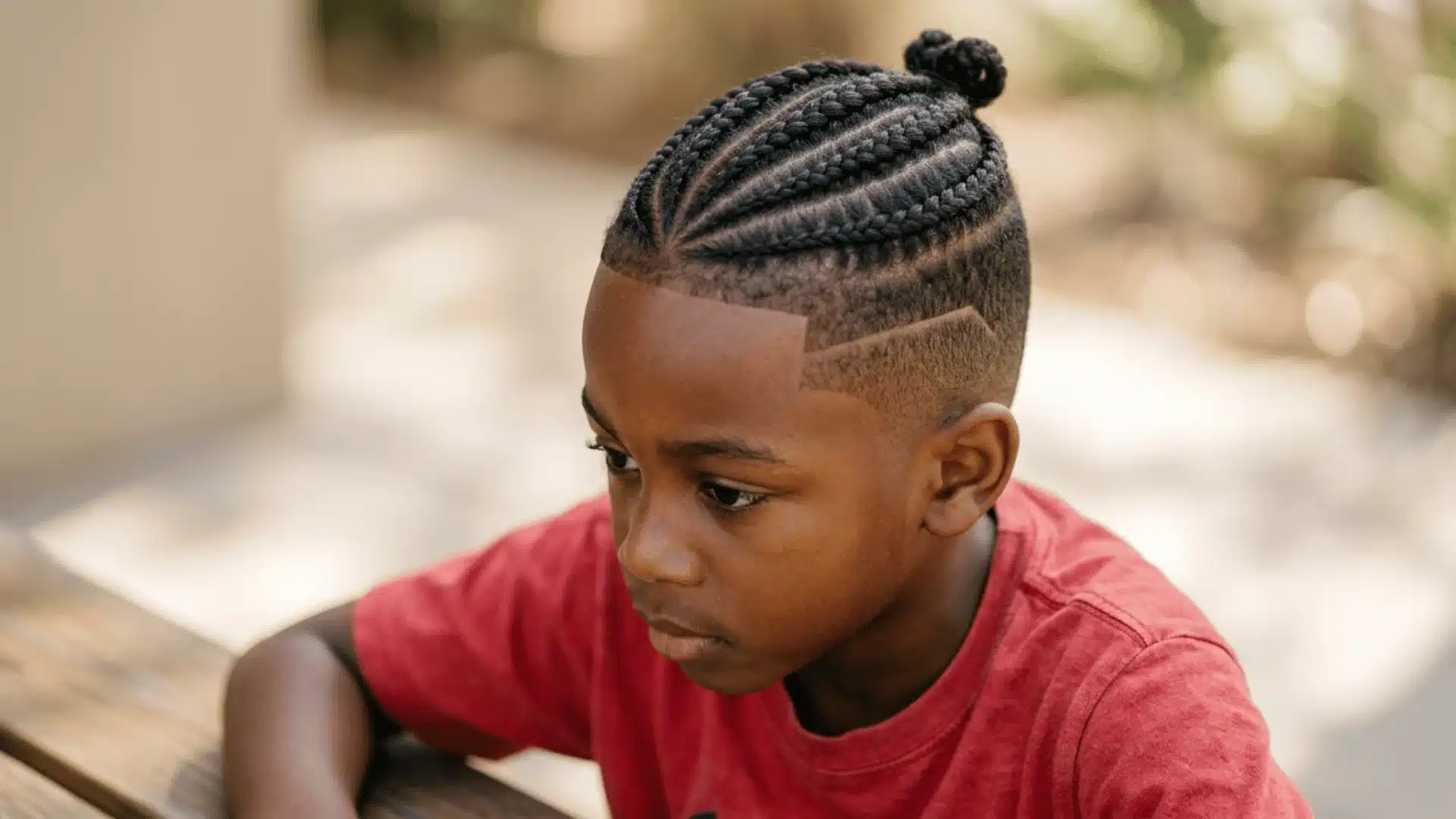 Mixed boy with cornrows on top and a clean fade along the sides