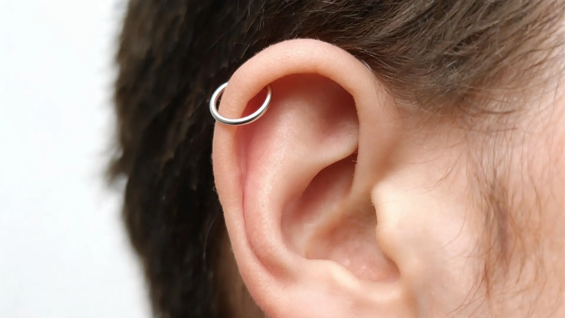 Silver helix piercing on outer ear cartilage