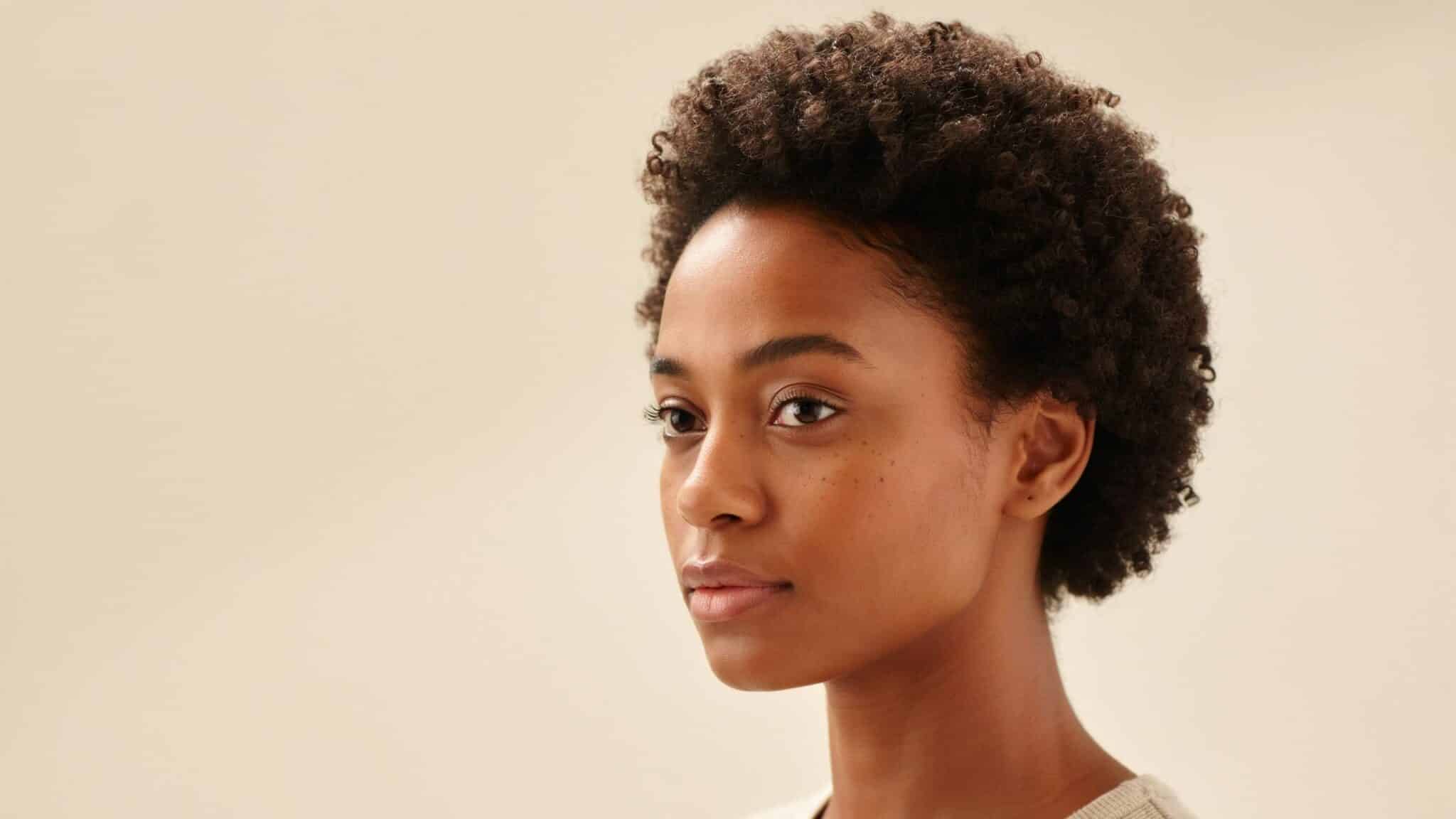 woman with two inch coily hair showing short natural coils and realistic hair texture