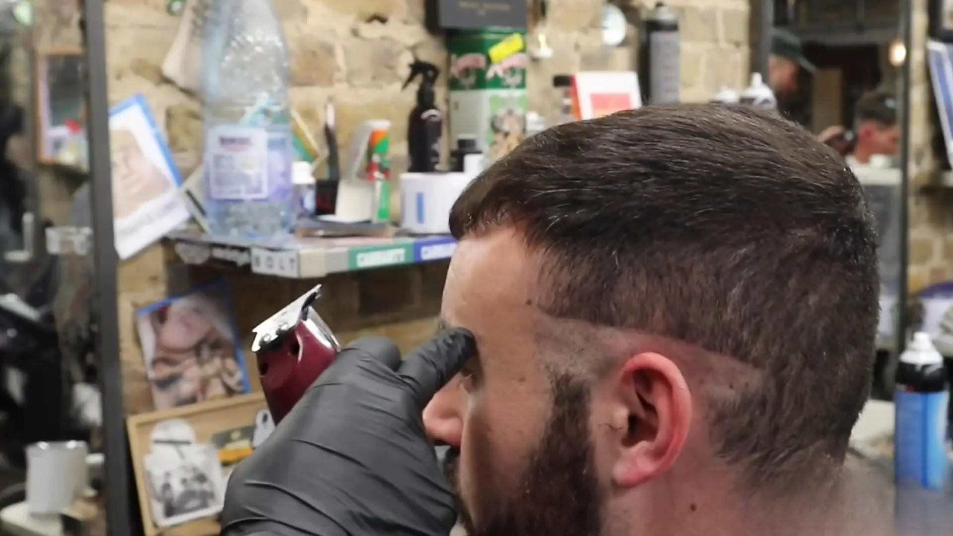 YouTube screen showing barber doing fade haircut tutorial with clipper and recommended videos sidebar