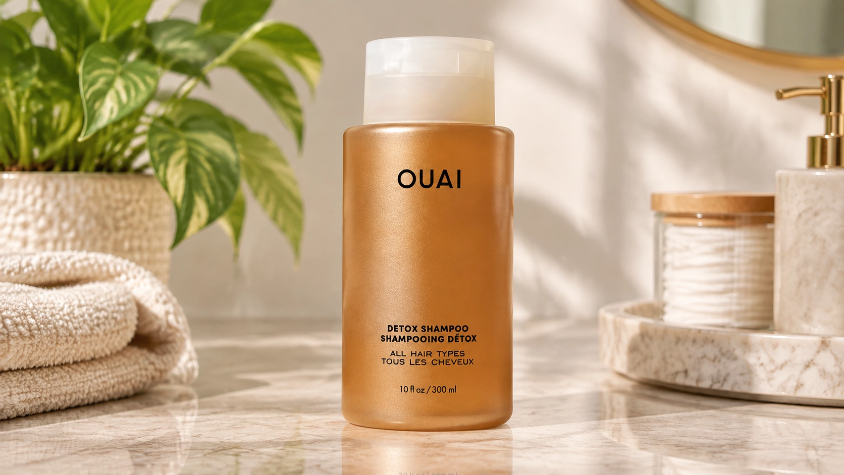 ouai detox shampoo bottle on a marble bathroom vanity with spa styling